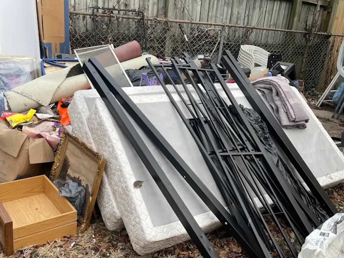 Backyard junk pile of mattresses and metal bed frames