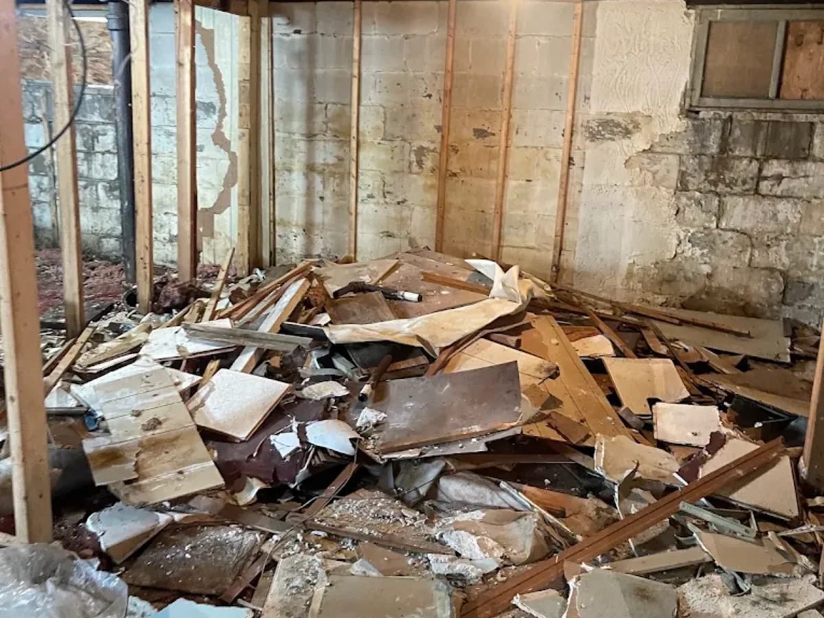 Basement demolition debris piled on a concrete floor