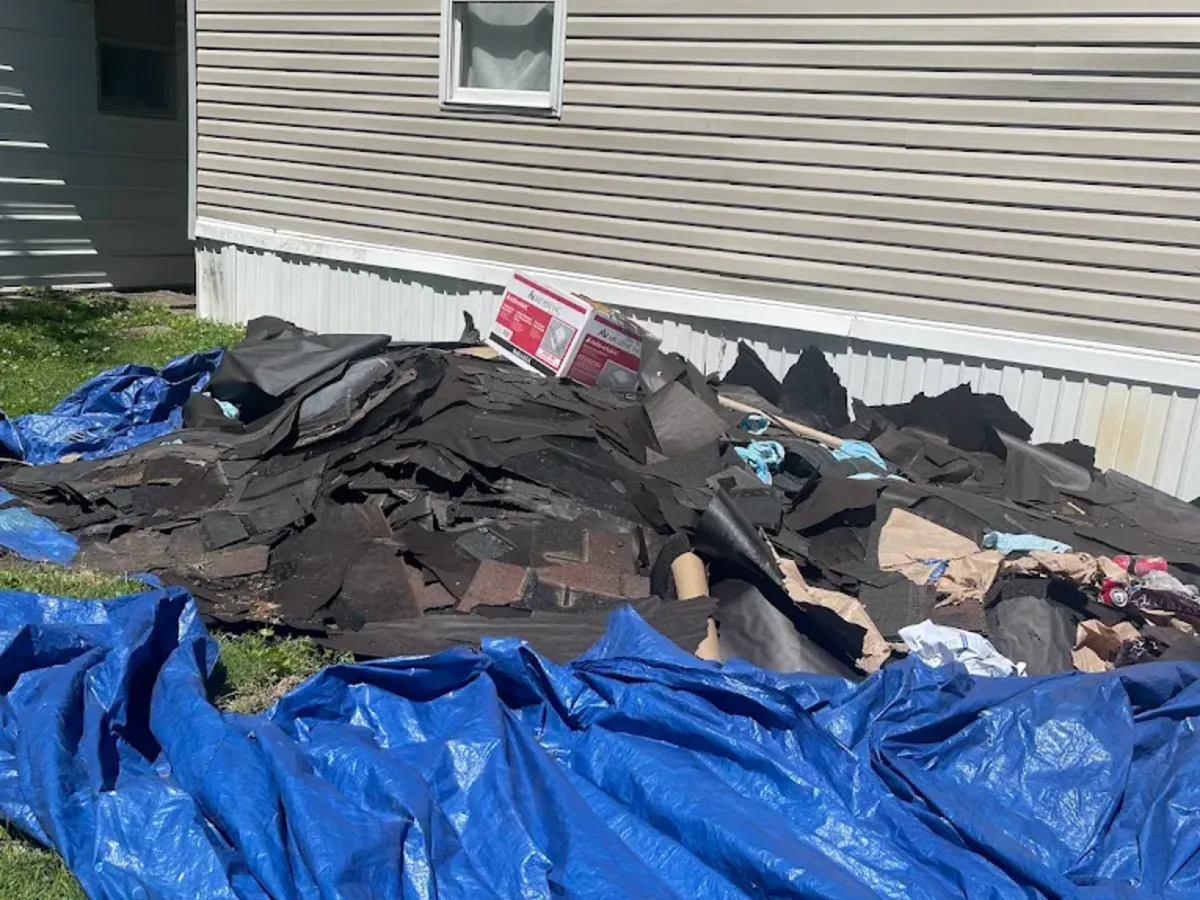 Roof shingle tear off debris piled on a tarp